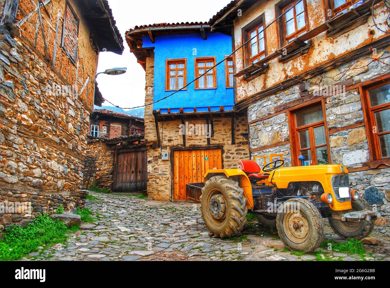 Historische Dorfhäuser und landwirtschaftliche Fahrzeug Traktor. Cumalıkızık / Bursa / Türkei Stockfoto