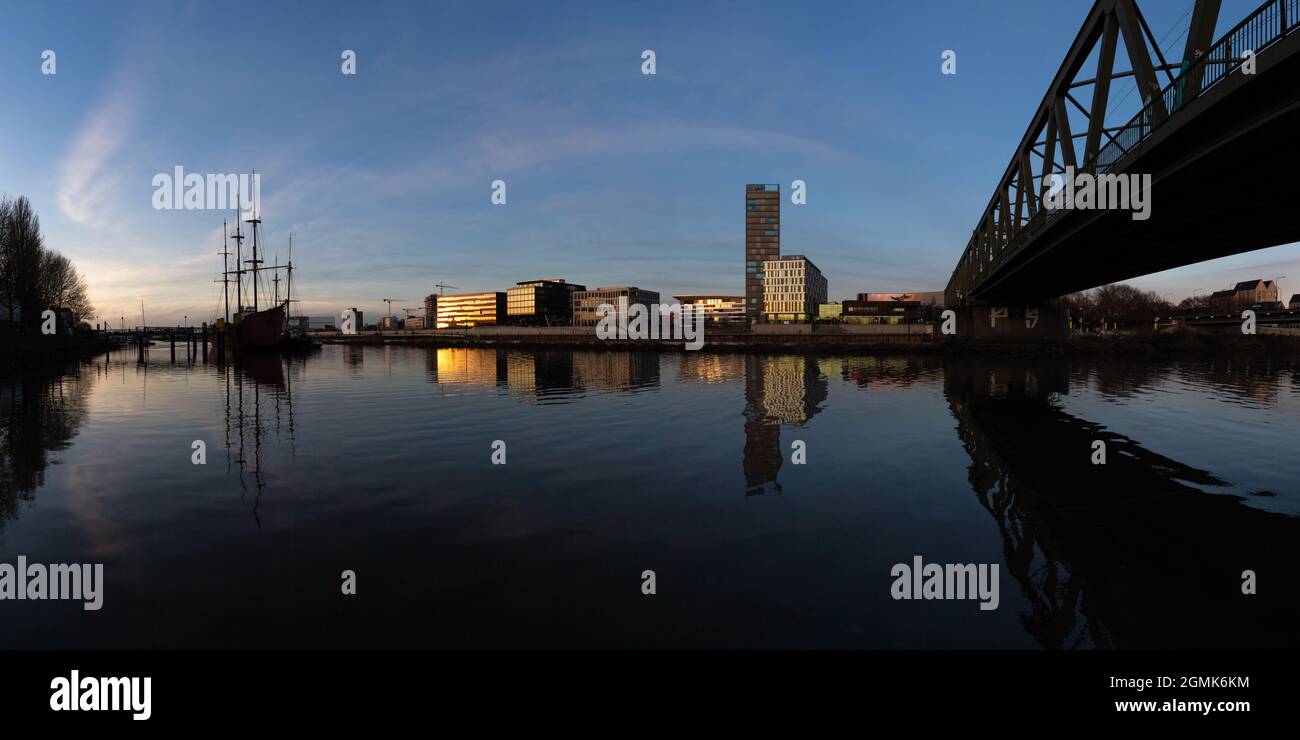 Panorama der Überseestadt, Bremen, Deutschland, ein Geschäftsviertel mit moderner Architektur an der Weser bei Sonnenuntergang Stockfoto