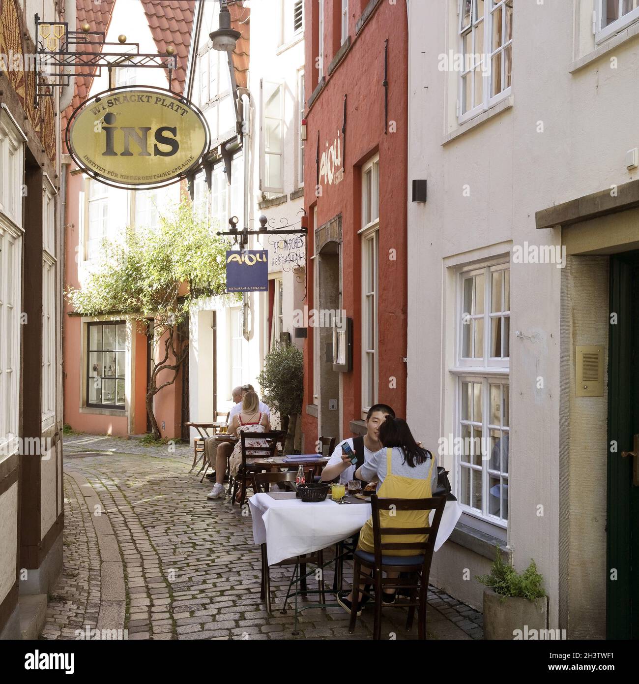 Outdoor-Gastronomie in einer kleinen Gasse in der Altstadt von Schnoor, Bremen, Deutschland, Europa Stockfoto