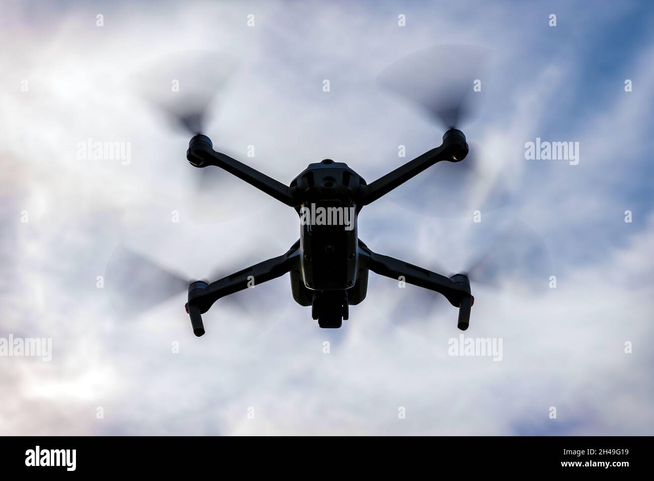 Fliegende Drohne Silhouette auf dunklen bewölkten Himmel Hintergrund Stockfoto