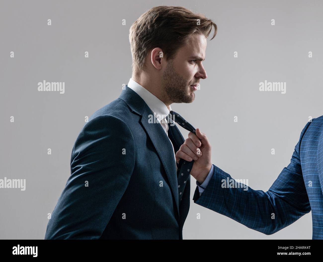 Konflikte am Arbeitsplatz. Mitarbeiter wird durch Krawatte gezogen. Physischer Konflikt. Aggression am Arbeitsplatz Stockfoto