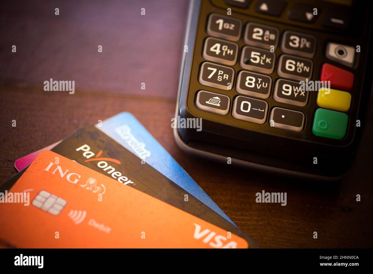 Revolut-, ING- und Payoneer-Karten in der Nähe eines POS-Terminals Stockfoto