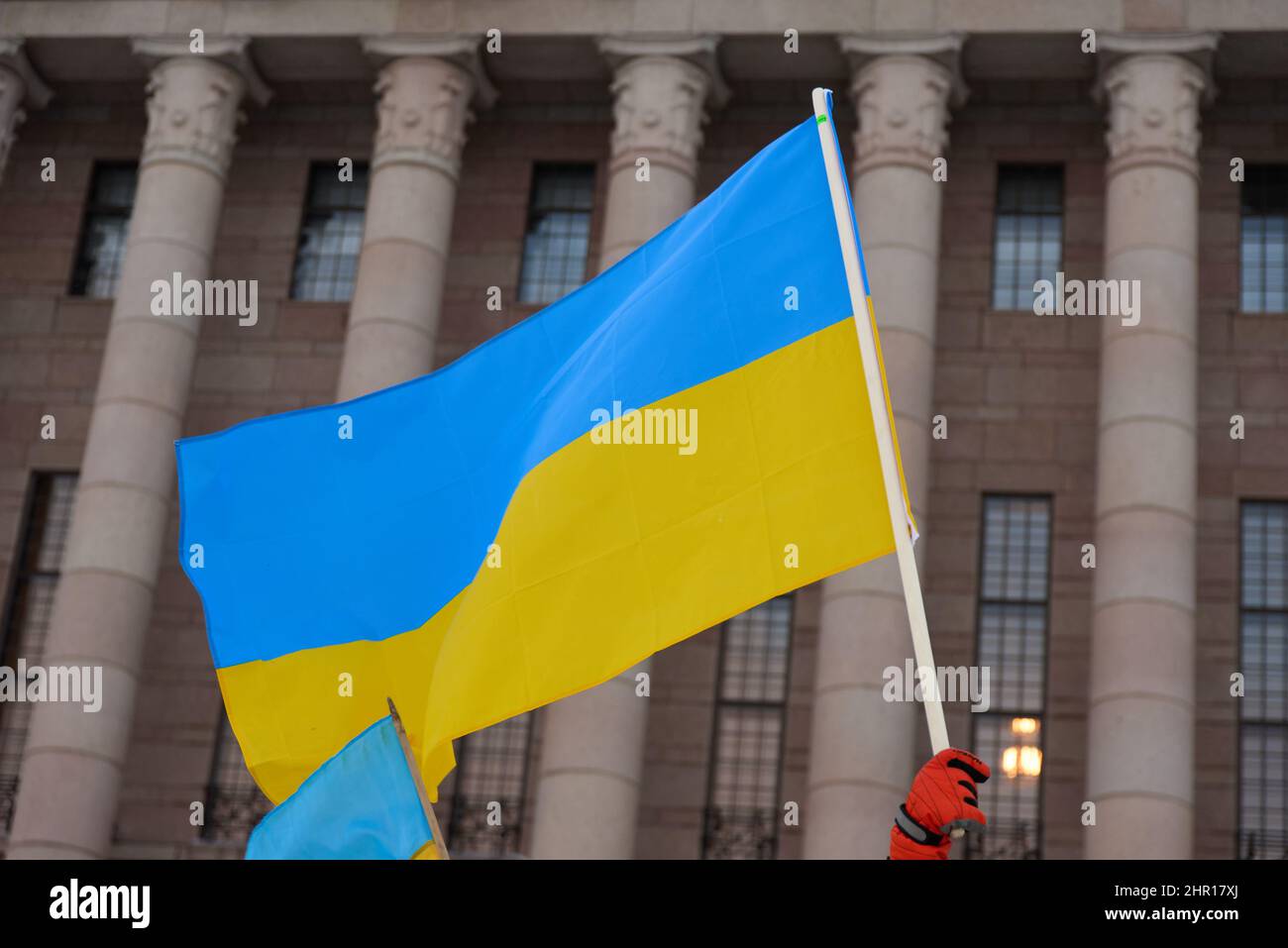 Helsinki, Finnland - 22. Februar 2022: Demonstrator bei einer Kundgebung gegen Russlands militärische Aggression und Besetzung der Ukraine mit ukrainischer Flagge Stockfoto