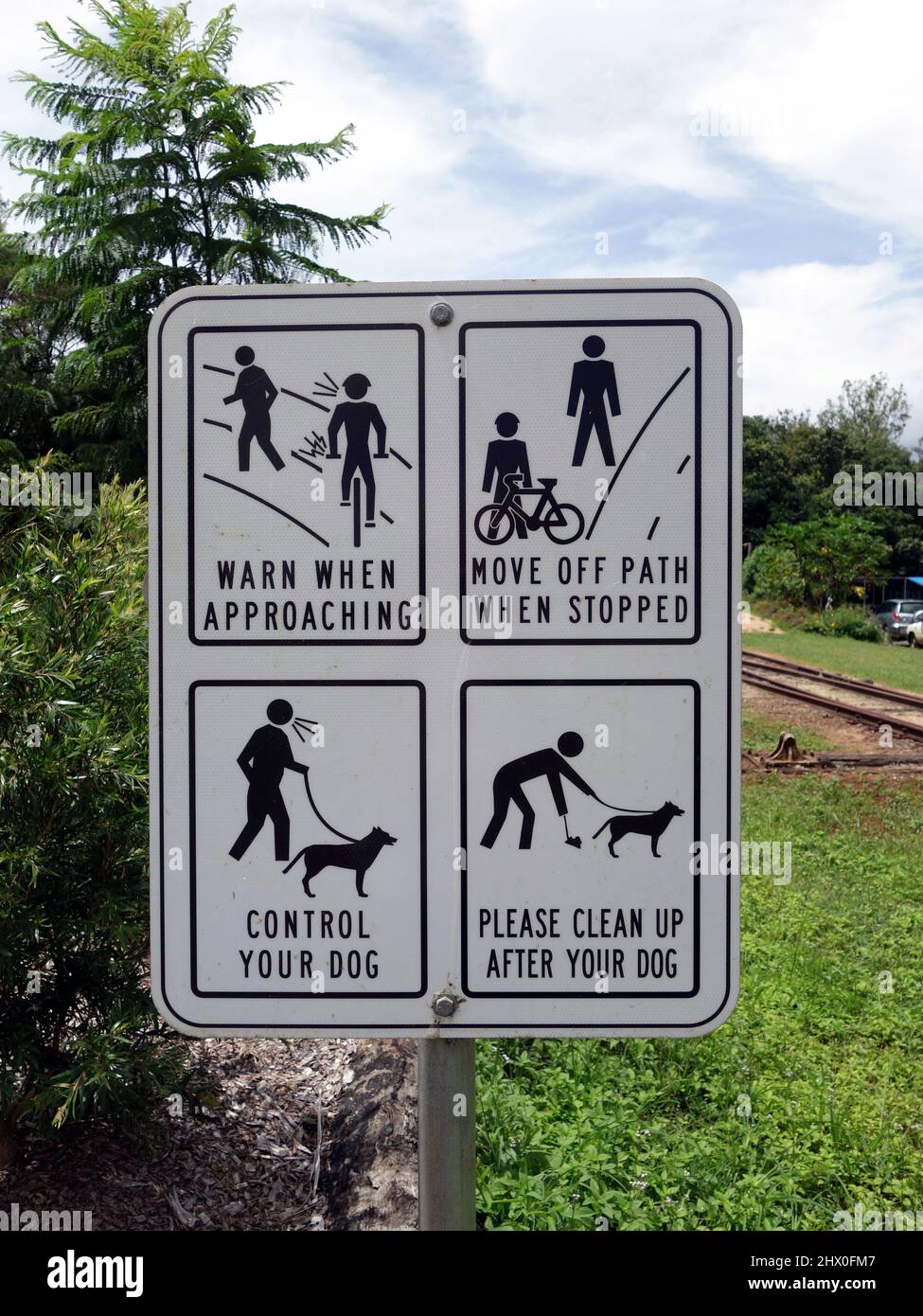 Ein Warnschild mit mehreren Meldungen für Radfahrer und Hunde Stockfoto