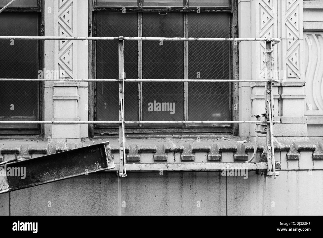 Alte Feuertreppe und Plattform in der Innenstadt von Chicago in schwarz-weißen Graustufen. Stockfoto