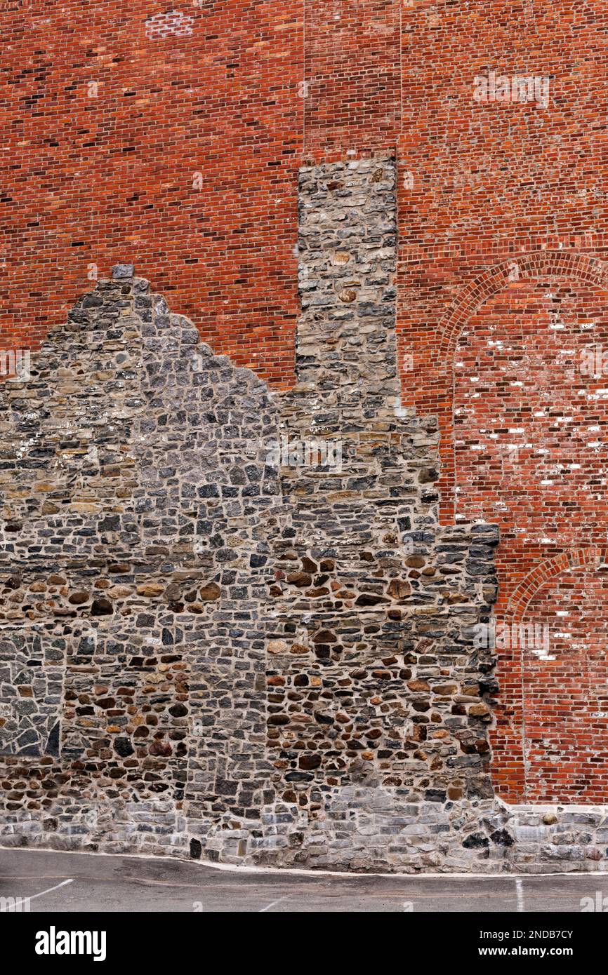 Kanada, Quebec, Montreal, Umriss eines alten Hauses in Feldstein als Teil eines roten Backsteingebäudes in Downtown Montreal Stockfoto