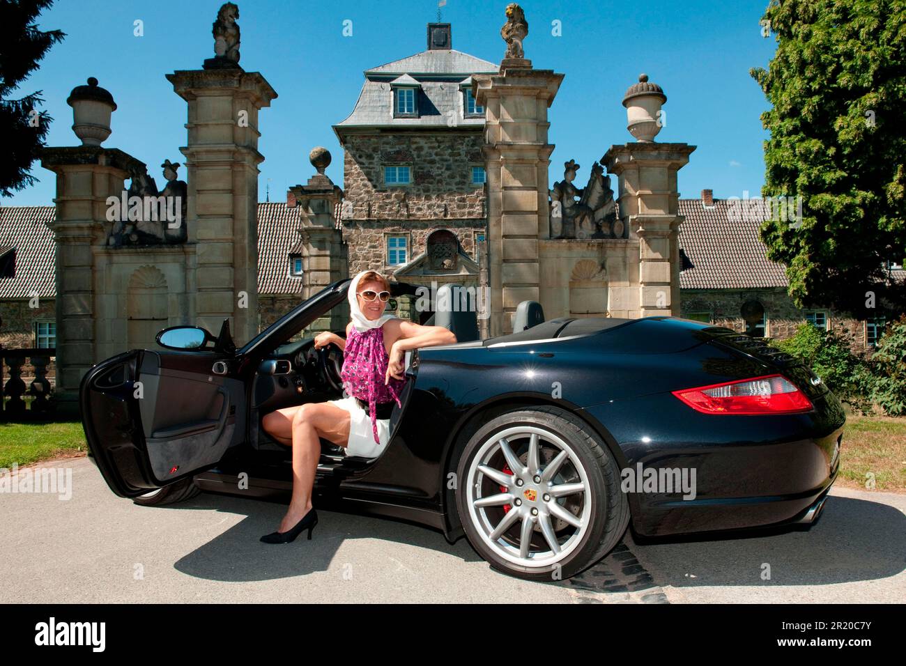 Frau mit Porsche 911 Cabriolet vor dem Schloss, Porsche Carrera 4S Cabriolet, Cabrio, Sportwagen Stockfoto