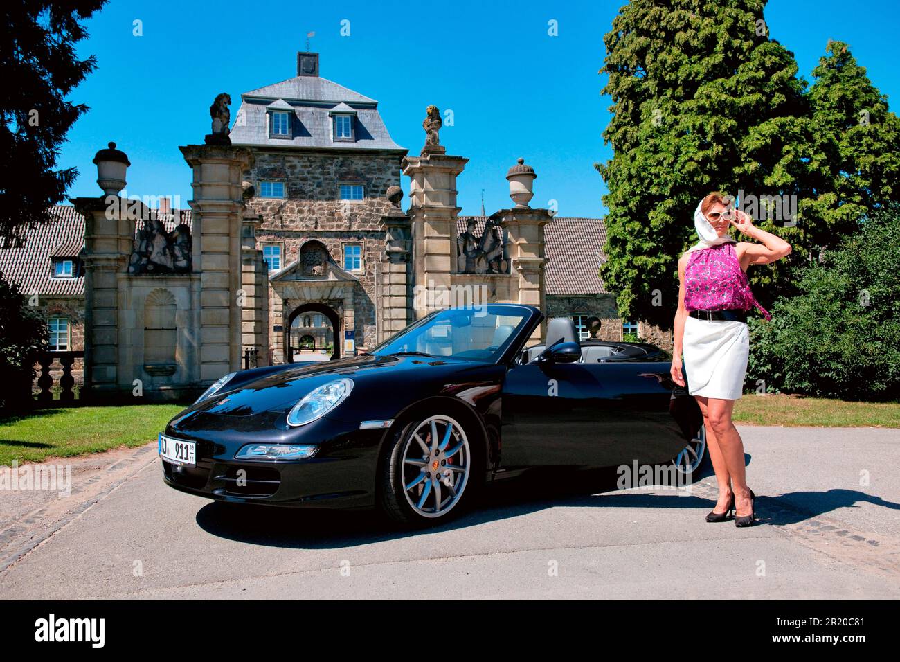 Frau mit Porsche 911 Cabriolet vor dem Schloss, Porsche Carrera 4S Cabriolet, Cabrio, Sportwagen Stockfoto