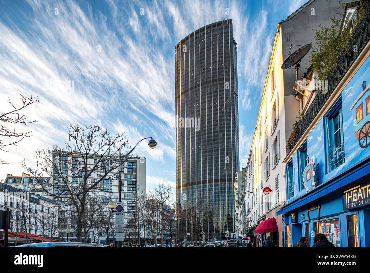 Der majestätische Wolkenkratzer Montparnasse steht vor einem Abendhimmel im belebten Paris. Stockfoto