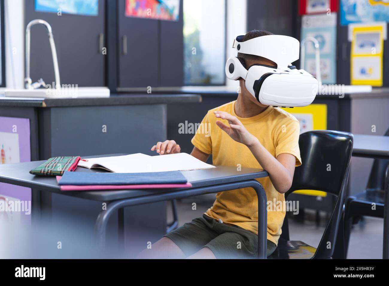 Biracial Boy erforscht die virtuelle Realität in einem Klassenzimmer in der Schule Stockfoto