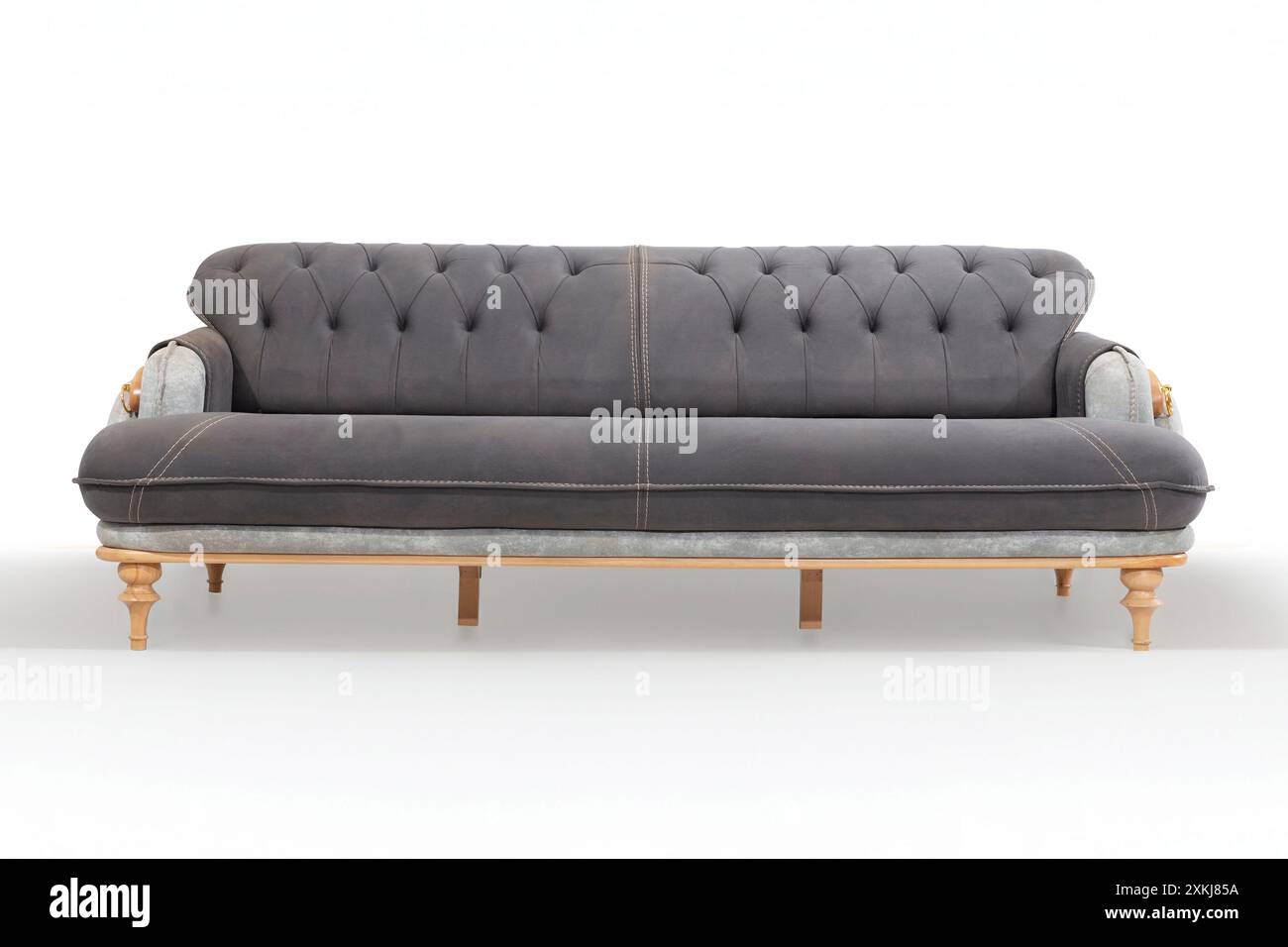 Konvertierbares graues Sofa mit getufteten Details und Holzbeinen, ideal für vielseitige Wohnräume. Stockfoto