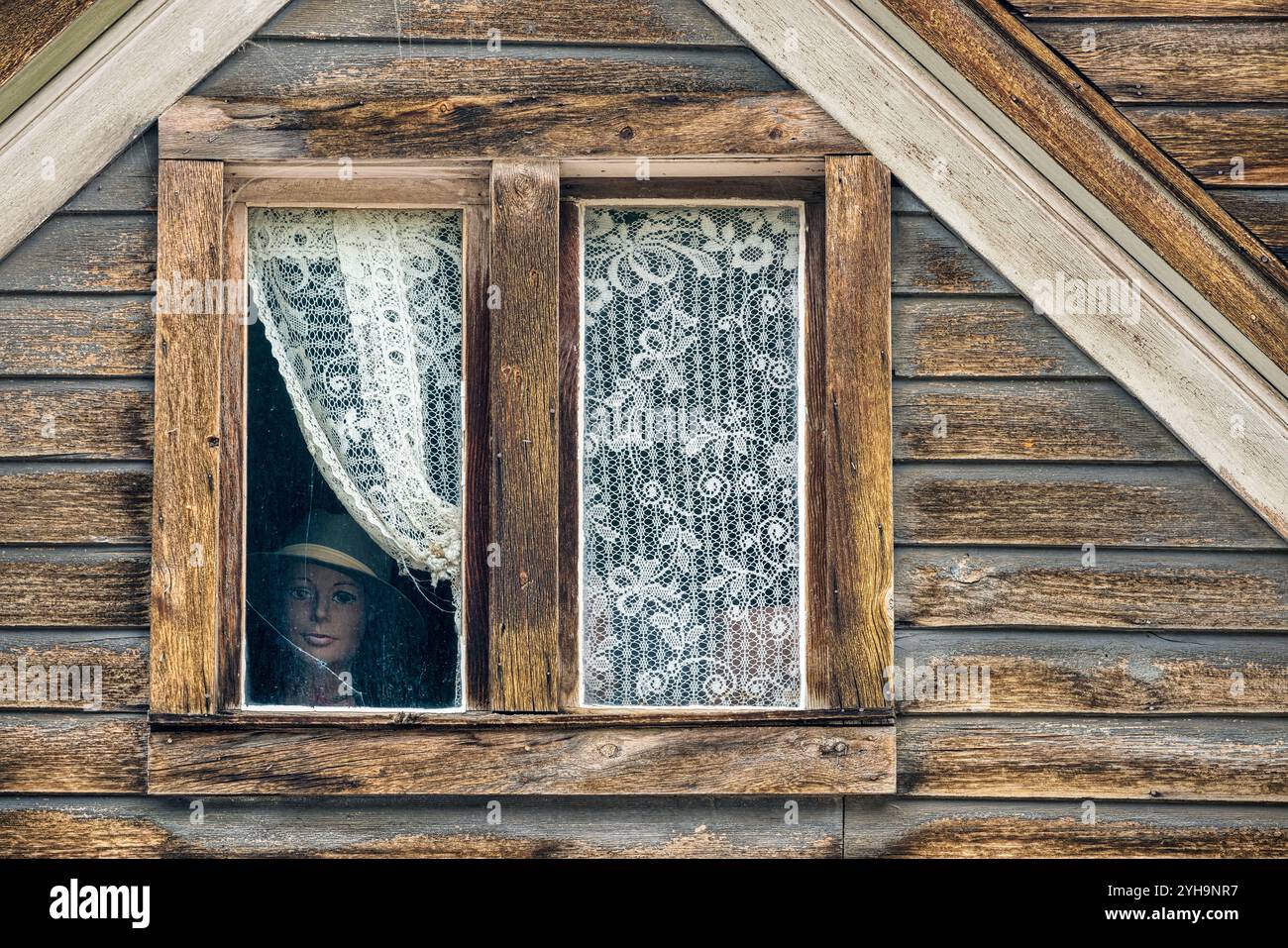 Schaufensterpuppe, die aus der Spitze eines Spukhauses wacht Stockfoto