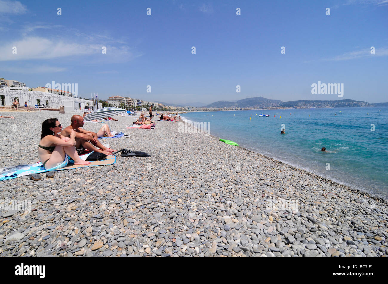 Menschen zum Sonnenbaden und genießen Sie die berühmte Kiesstrand in Nizza an der französischen Riviera, Südfrankreich. Stockfoto