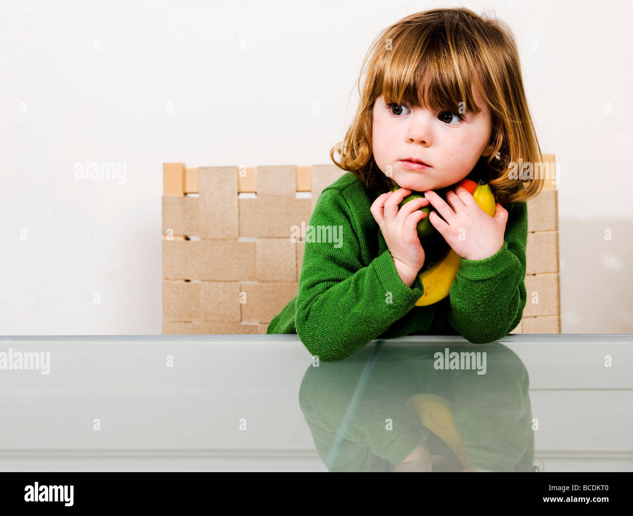 junges Mädchen mit Obst in Armen hält Stockfoto