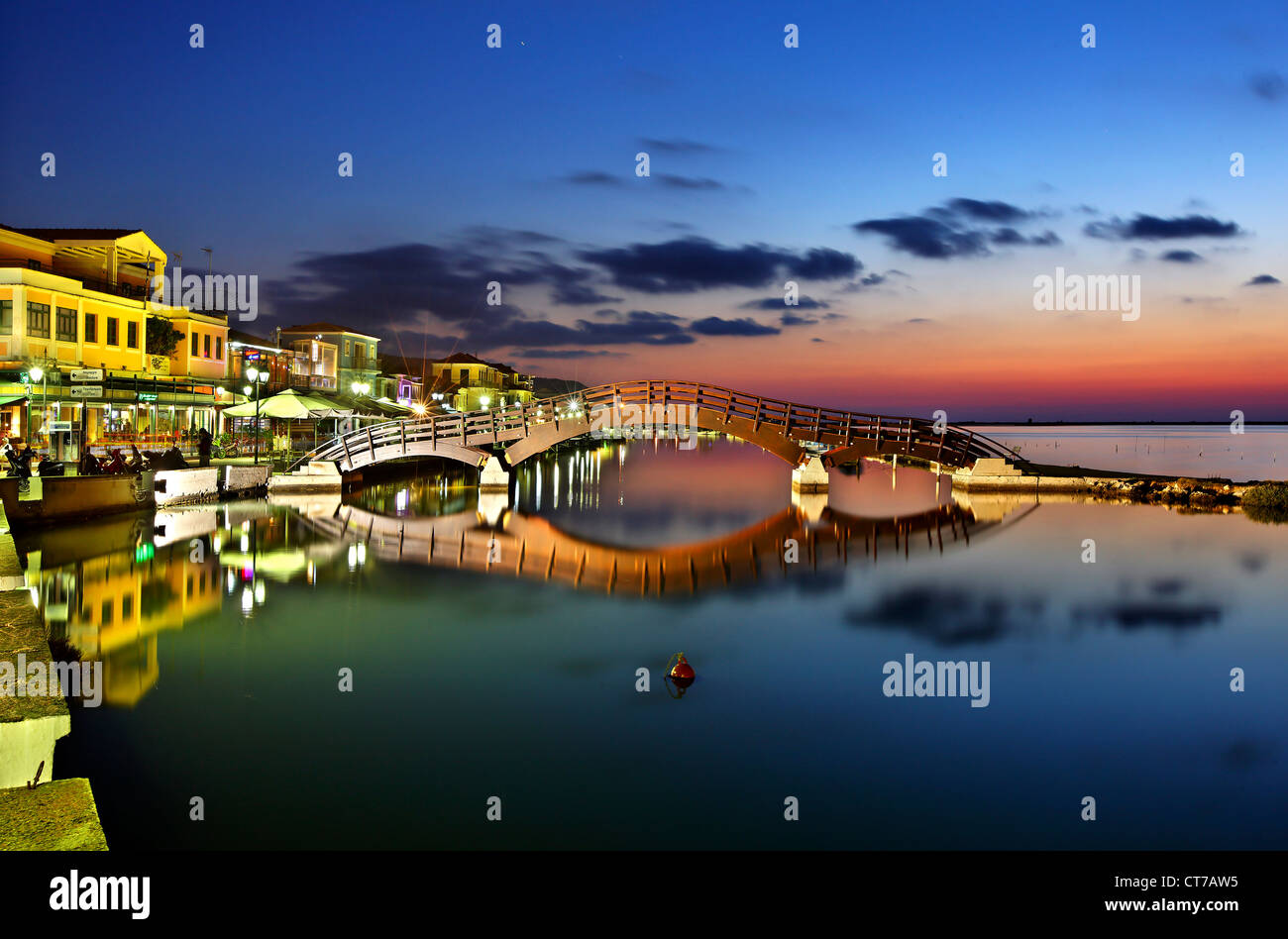 Sonnenuntergang in Lefkas (Lefkada) Stadt, in der kleinen Marina für die Fischerboote mit schöne Holzbrücke. Ionische Inseln, Griechenland. Stockfoto