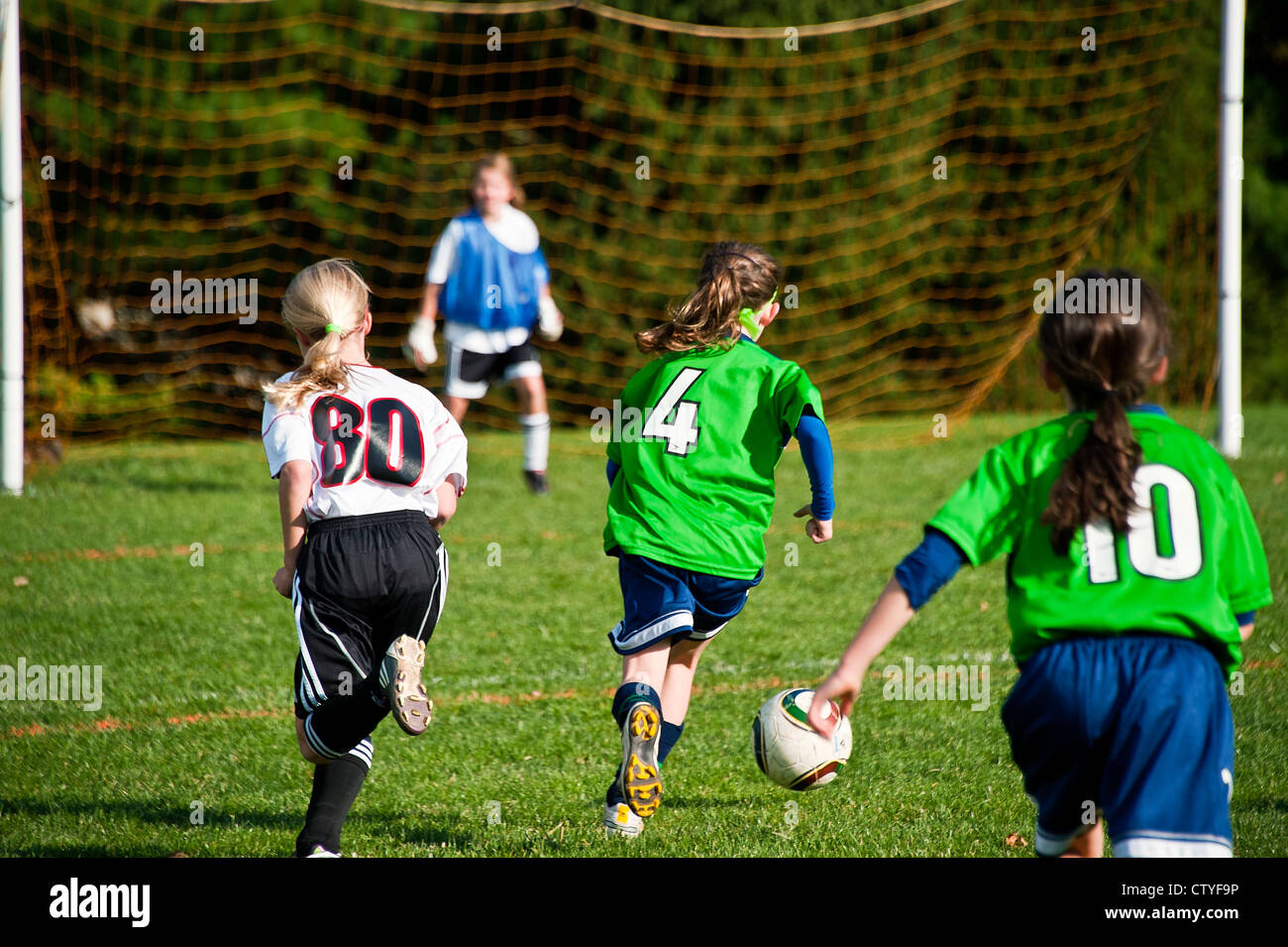 Jugend-Fußball-Mädchen dribbelt Fußball Ball zum Ziel. Stockfoto