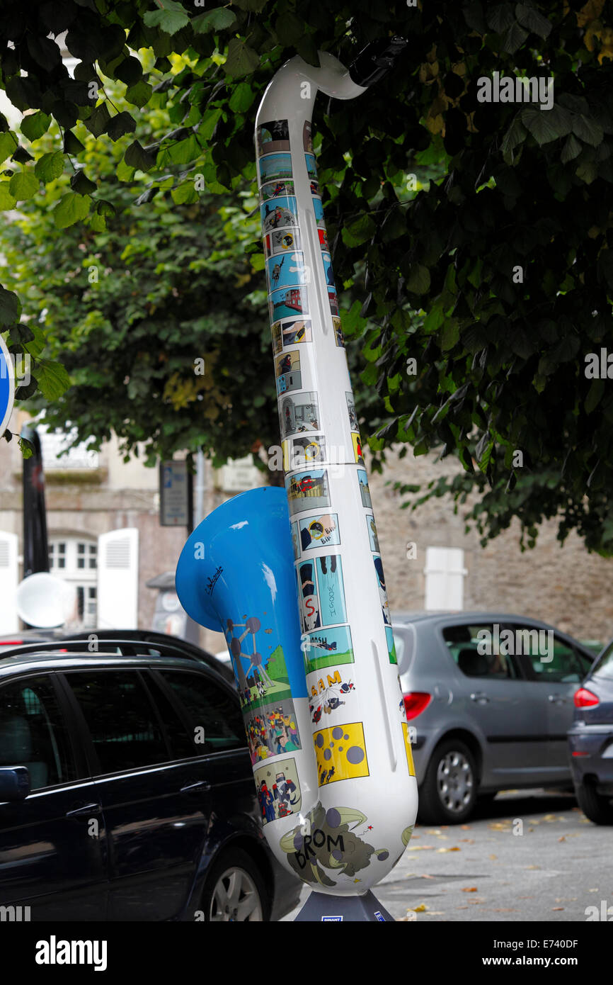 Saxophon Straße Skulptur von Cedric Belconde. Bedeckt in Karikaturen Stockfoto