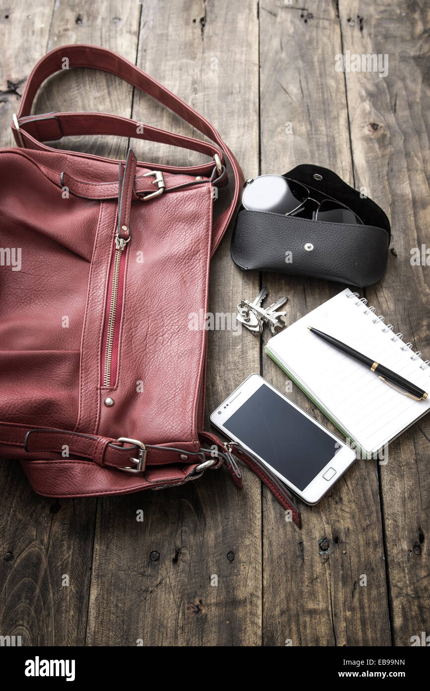 Frau Tasche stopfen, Handtasche über rustikale Holz Hintergrund Stockfoto