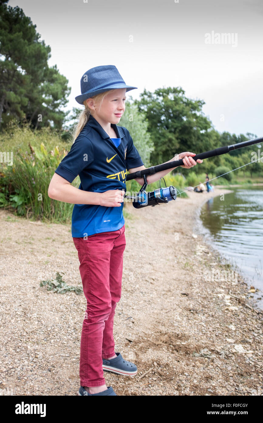 Junge neun Jahre alte Blondine Fliegenfischen am See Stockfoto