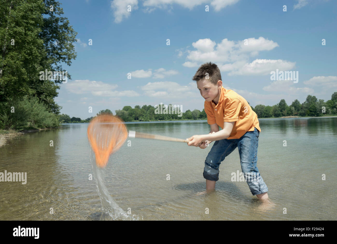 Junge Fang von Fischen mit Fischernetz in der See, Bayern, Deutschland Stockfoto