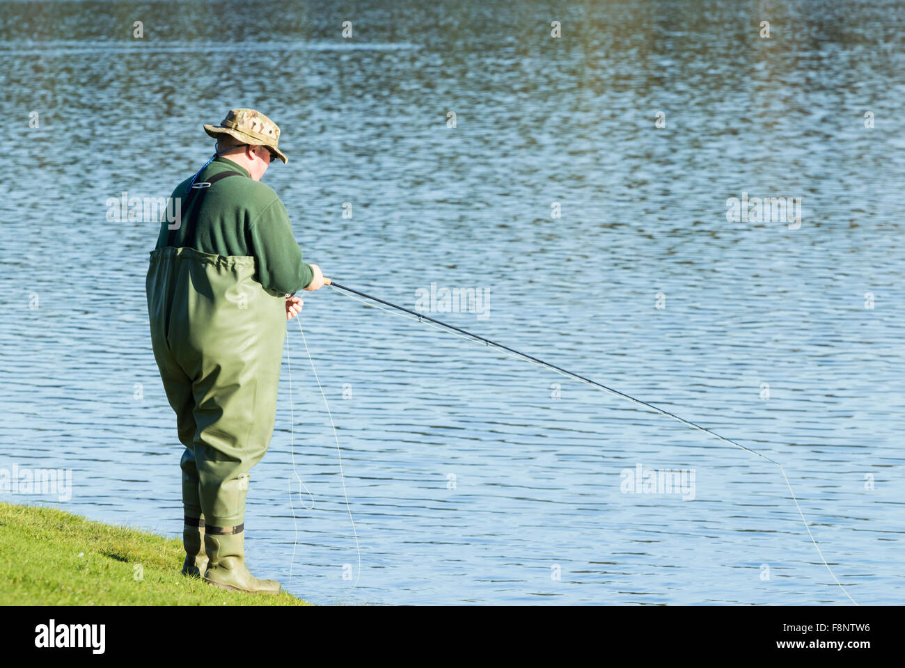 Mann Fliegenfischen am Stausee Stockfoto