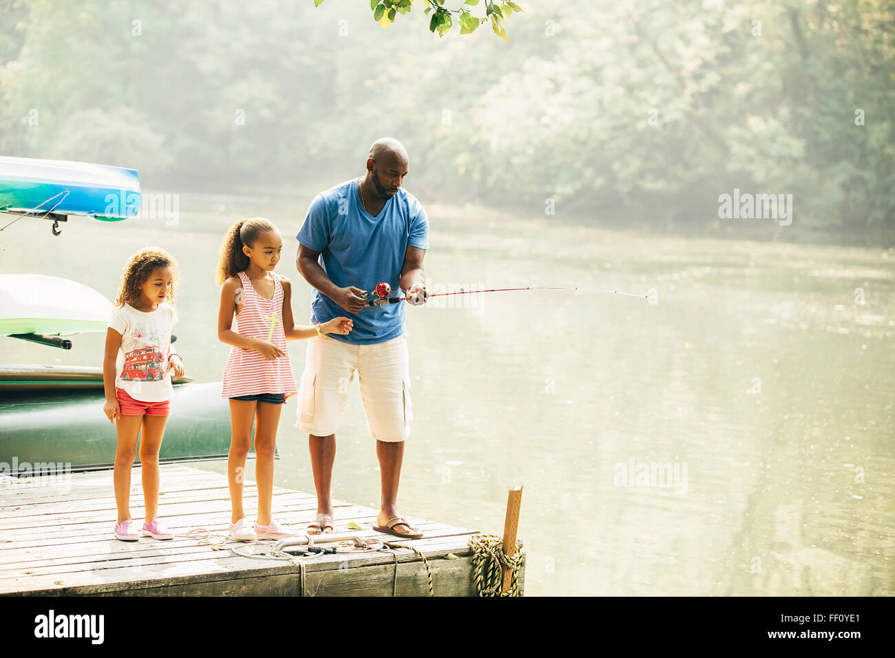 Vater und Töchter Angeln im See Stockfoto