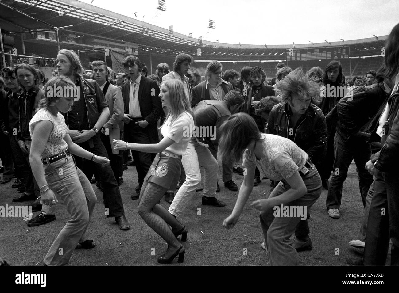 Rock-Enthusiasten im Wembley Stadium, wo viele Tausende an einem Rock 'n' Roll-Festival teilnahmen, das Mode von vor zwei Jahrzehnten hatte. Stockfoto