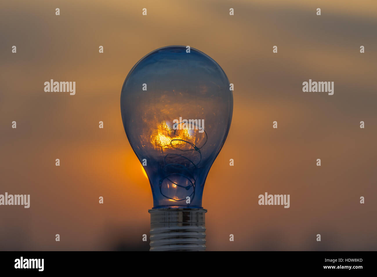 Geniale Idee, Glühbirne und Sonnenuntergang Himmel. Stockfoto