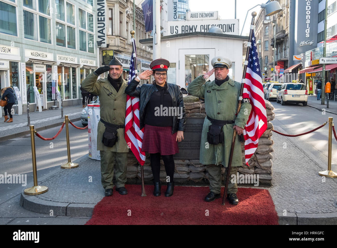 Touristen posieren mit amerikanischen Soldaten am Checkpoint Charlie in Berlin, Deutschland Stockfoto