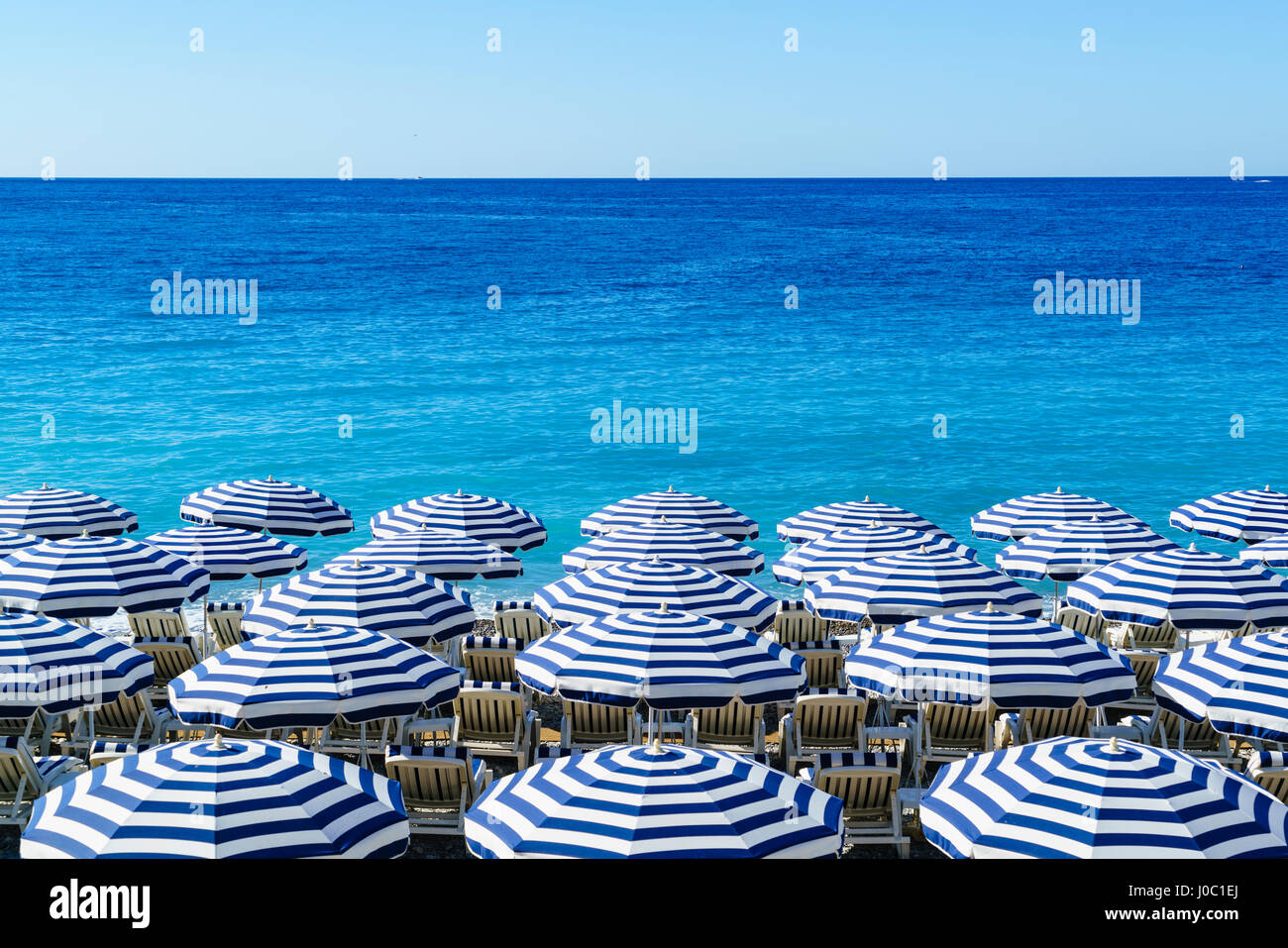 Blaue und weiße Strand Sonnenschirme, Nizza, Alpes Maritimes, Cote d ' Azur, Provence, Frankreich, mediterran Stockfoto