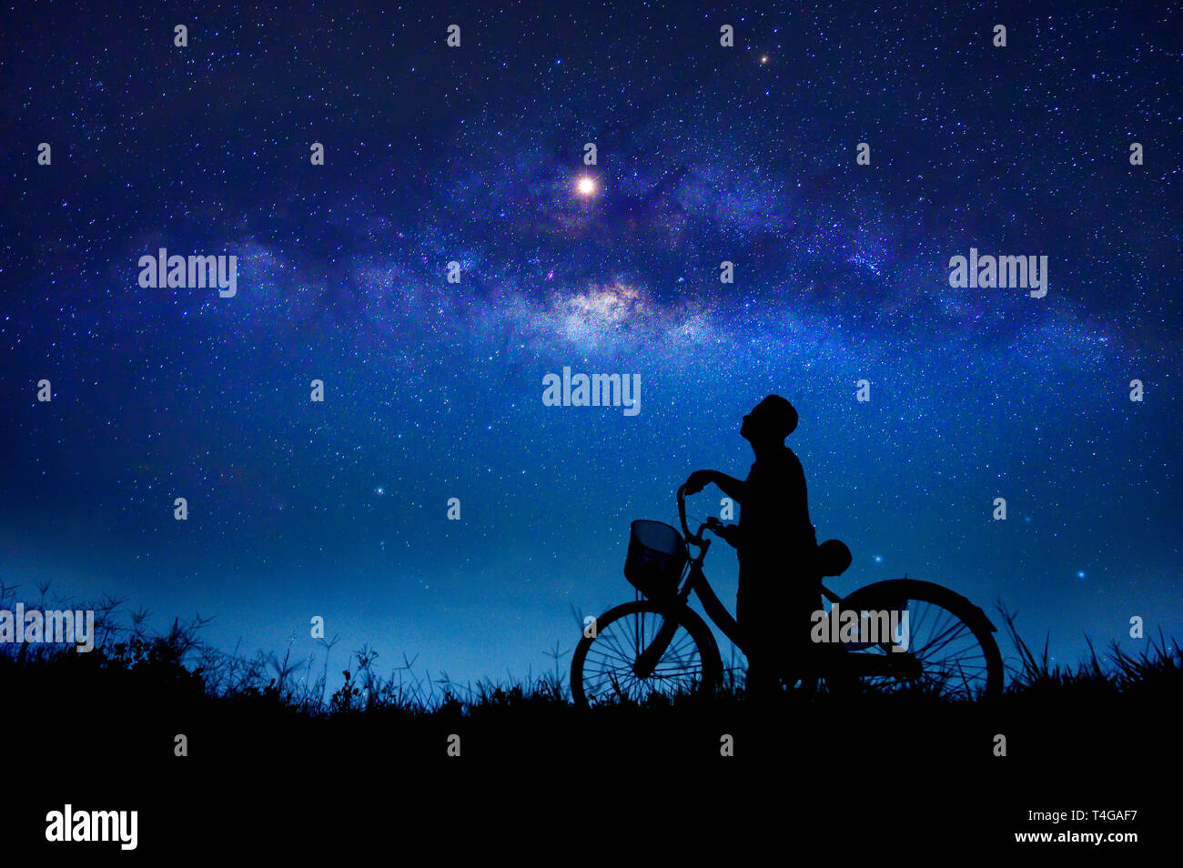 Der Junge ist Radfahren in der Mitte der Sterne Galaxie Stockfoto