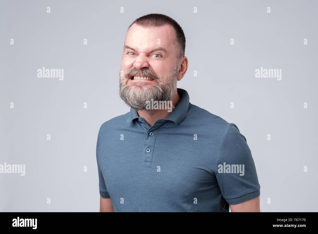 Reifer Mann wütend und aggressiv fletscht die Zähne. Stockfoto