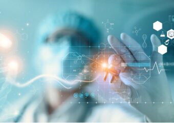 Image of a doctor in mask, gloves, and hair covering with a digital representation of a DNA molecule in their hand. Image is against a light blue background and focus is on their left hand.