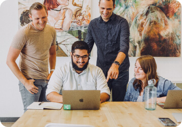 4 people looking at one computer