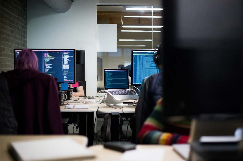 2 People Working with Multiple Computer Screens