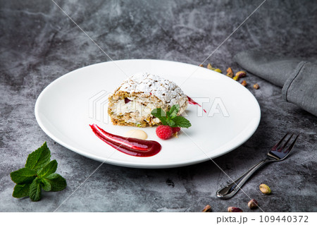 sweet sponge dessert with raspberries and powdered sugar side view 109440372