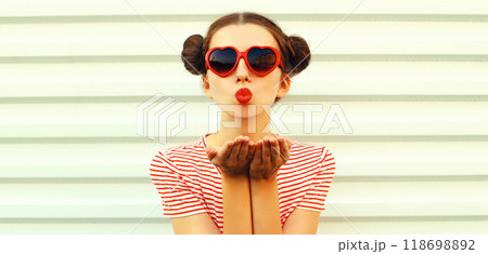 Portrait stylish young woman blowing kiss with red lipstick with cool hairstyle on white background 118698892